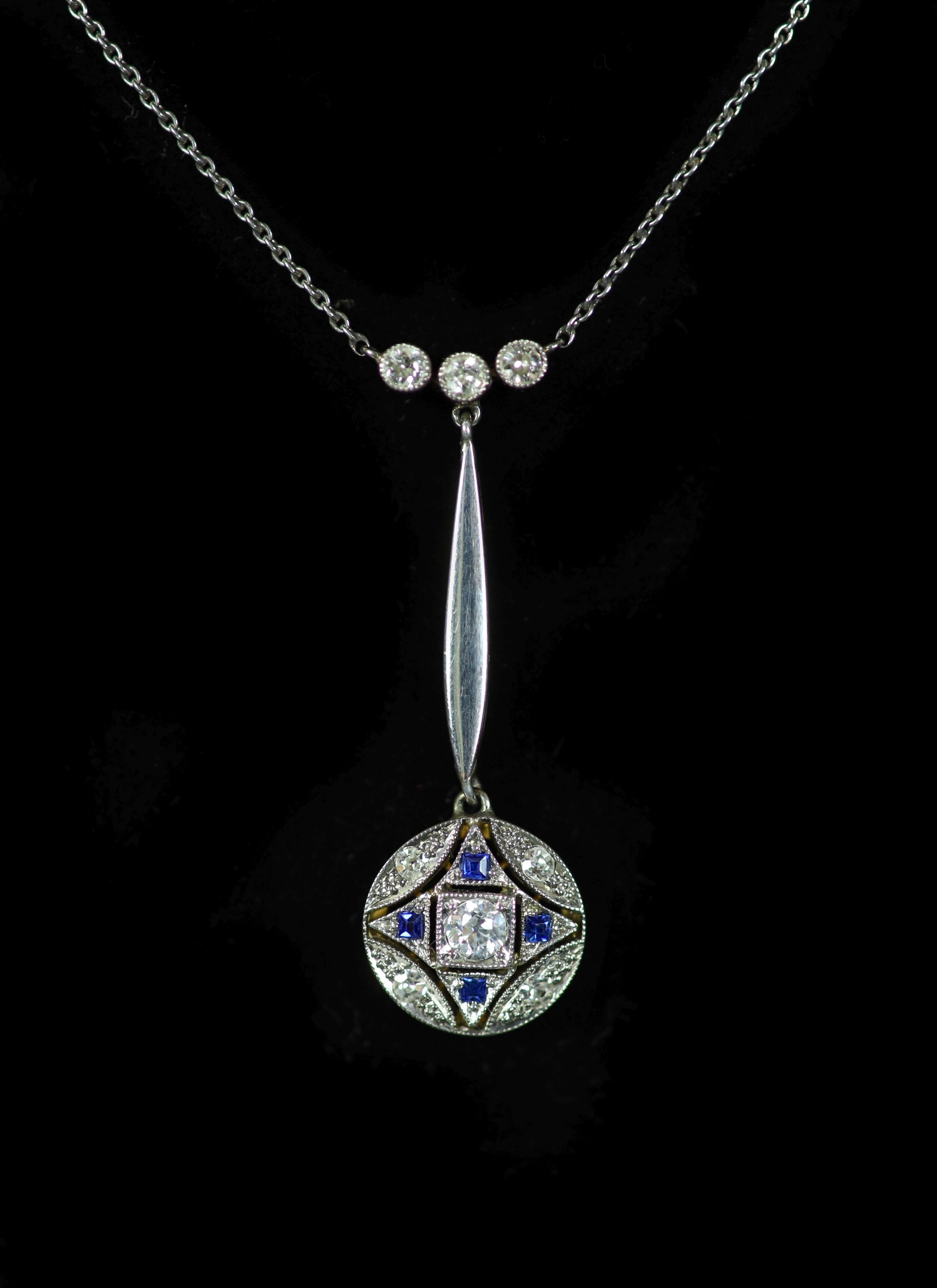 An Edwardian gold and platinum, millegrain set sapphire and diamond cluster set drop pendant necklace